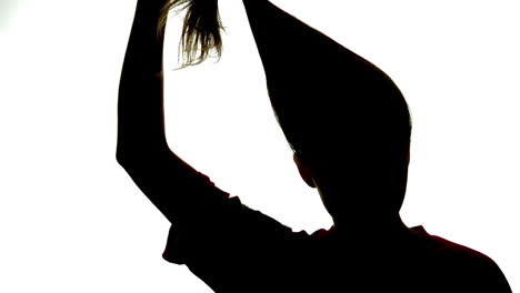 Silhouette-of-attractive-woman-taking-down-her-ponytail