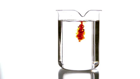 Drops-of-red-liquid-falling-into-beaker