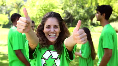 Happy-environmental-activist-smiling-at-camera-with-team-behind-her