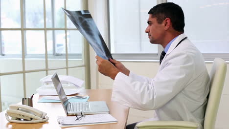 Arzt-Sitzt-Am-Schreibtisch-Und-Betrachtet-Röntgenbilder