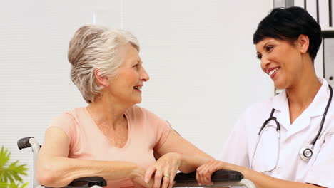 Nurse-talking-with-elderly-patient-in-a-wheelchair