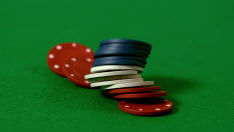 Casino-chips-falling-on-green-table