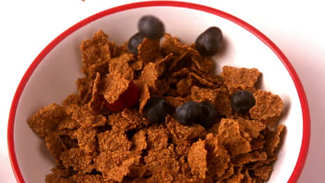 Berries-pouring-into-cereal-bowl