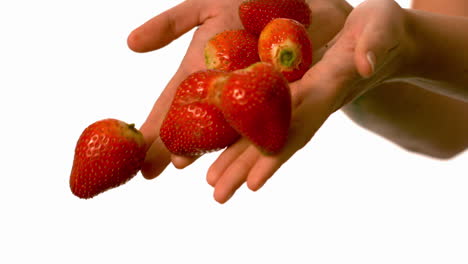 Woman-letting-go-of-strawberries-from-her-hands