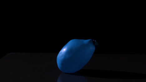 Blauer-Wasserballon-Fällt-Auf-Schwarzem-Hintergrund