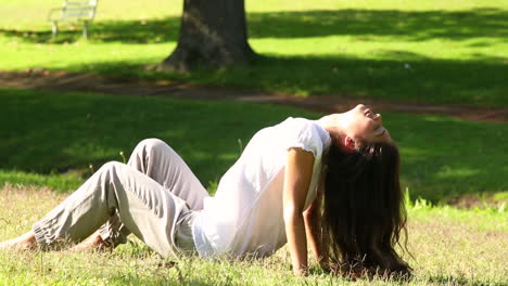 Linda-Chica-Sentada-En-La-Hierba-Disfrutando-Del-Sol