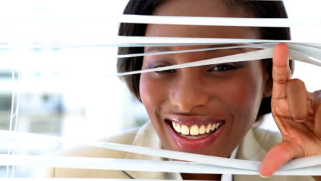 Businesswoman-looking-through-blinds