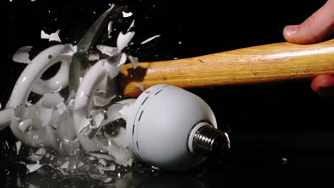 Hammer-smashing-light-bulb-on-black-background