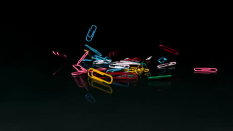 Paperclips-falling-on-black-background