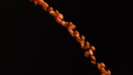Peanuts-pouring-against-black-background