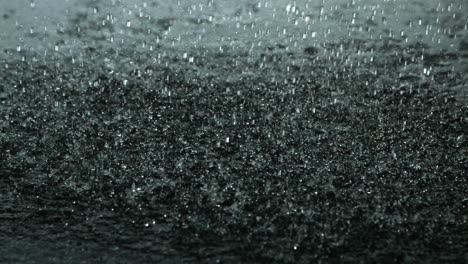 Rain-falling-on-black-surface