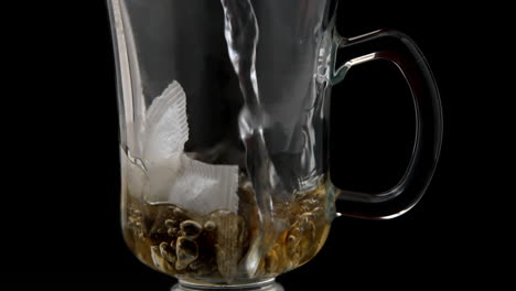 Hot-water-pouring-over-tea-bag-in-glass-