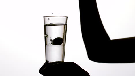 Silhouette-of-woman-dropping-vitamin-tablet-in-water