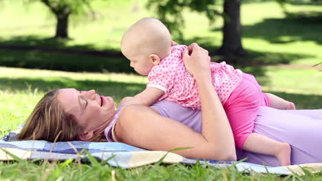 Happy-mother-playing-with-her-baby-girl-in-the-park