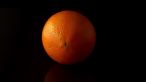Orange-spinning-on-black-surface