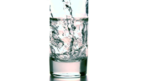 Wasser-Gießt-In-Ein-Glas-Auf-Weißem-Hintergrund