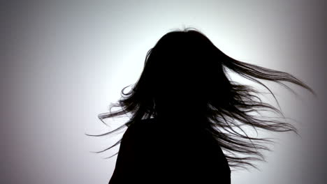 Silhouette-of-attractive-woman-tossing-her-hair