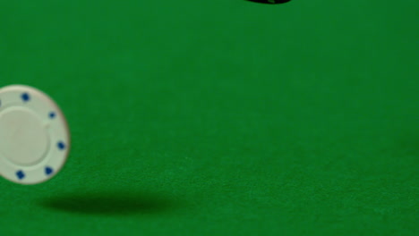 Casino-chips-falling-on-green-table