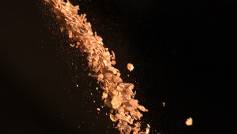 Cereal-flakes-falling-against-black-background