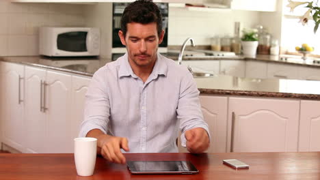 Handsome-man-using-tablet-pc-at-the-table
