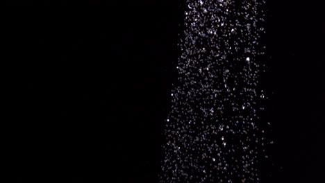 Water-raining-against-black-background