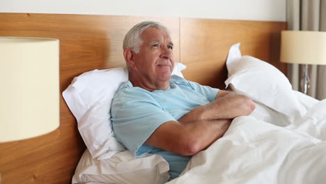 Senior-man-lying-in-bed-thinking