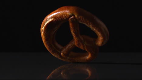 Pretzel-spinning-on-black-surface