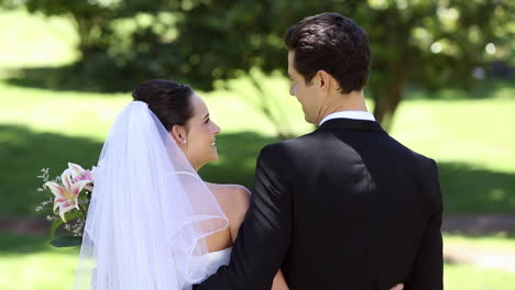 Happy-newlyweds-standing-in-the-park