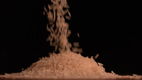 White-rice-pouring-on-black-background