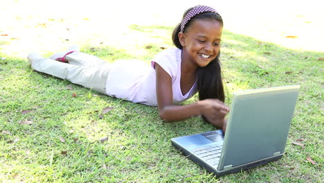 Kleines-Mädchen-Liegt-Auf-Dem-Rasen-Mit-Laptop