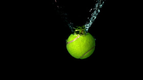 Tennis-ball-falling-in-water-on-black-background