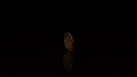 Two-euro-coin-spinning-on-black-background