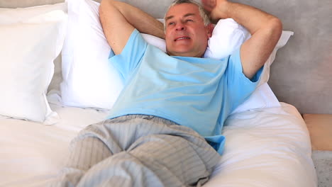 Senior-man-relaxing-on-his-bed