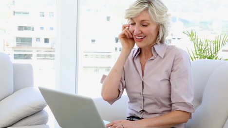 Businesswoman-talking-on-phone-and-using-laptop