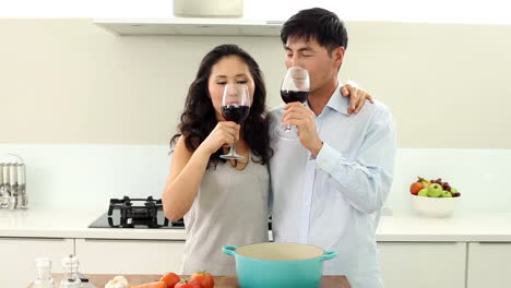 Couple-making-dinner-and-drinking-red-wine