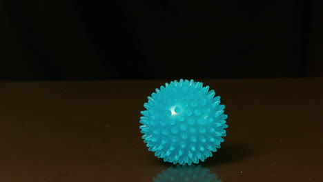 Massage-ball-bouncing-on-black-surface