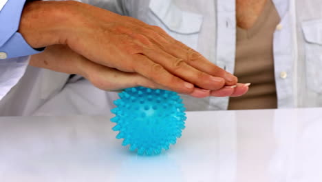 Doctor-Explicando-Una-Pelota-De-Masaje-Al-Paciente.