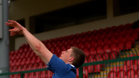 Football-player-in-blue-throwing-the-ball