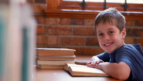 Little-boy-reading-book-in-classroom