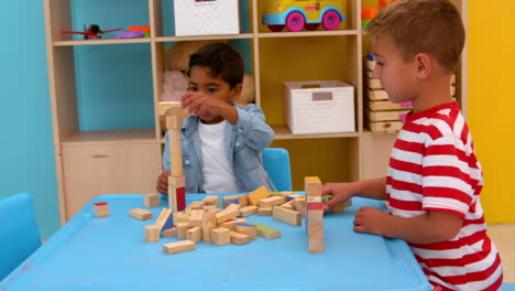 Cute-little-boys-playing-with-building-blocks-at-table-in-classroom