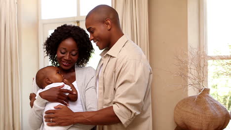 Pareja-Feliz-Sosteniendo-A-Su-Hijo