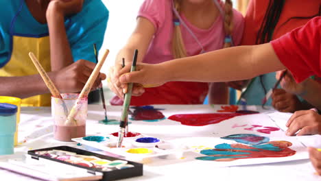 Preschool-class-painting-at-table-in-classroom