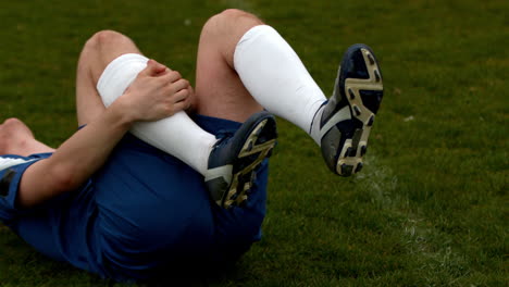 Football-player-in-blue-falling-down-injured