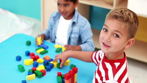 Lindos-Niños-Jugando-Con-Bloques-De-Construcción-En-La-Mesa