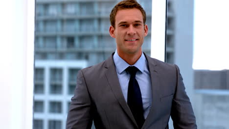 Handsome-businessman-smiling-at-camera