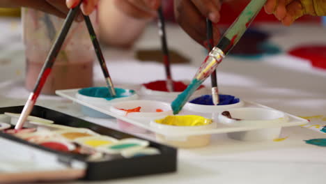 Preschool-class-painting-at-table-in-classroom