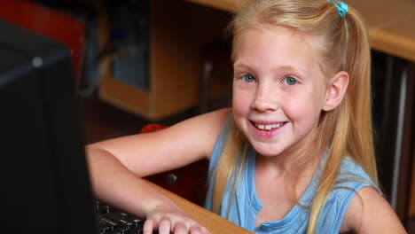 Little-girl-smiling-at-camera-during-computer-class