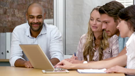 Equipo-De-Negocios-Informal-Que-Tiene-Una-Reunión-Usando-Una-Computadora-Portátil