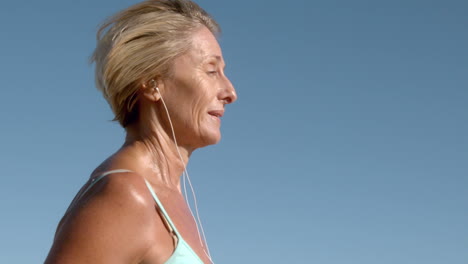 Senior-woman-jogging-on-a-sunny-day-listening-to-music