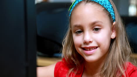 Little-girl-smiling-at-camera-during-computer-class